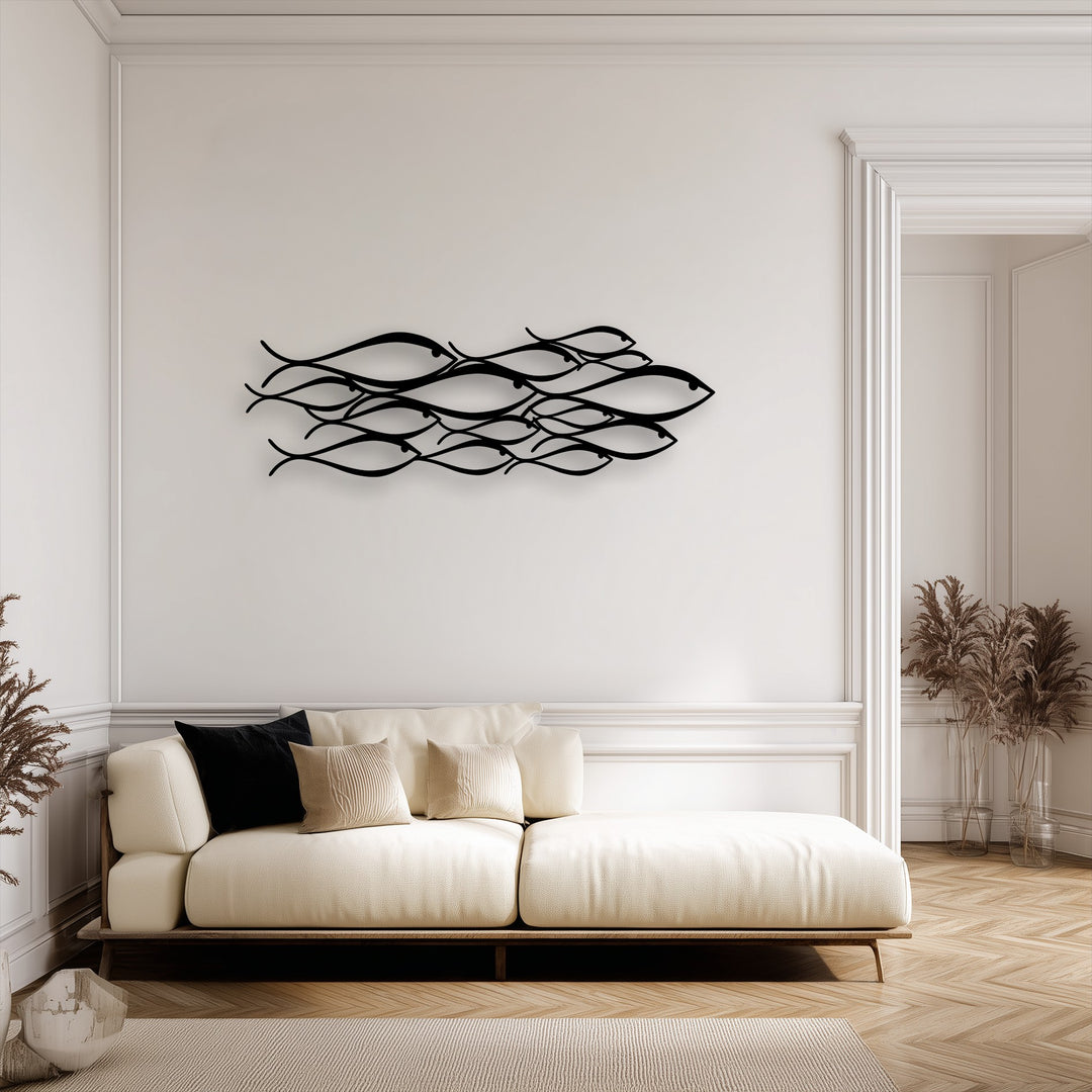 The sleek matte texture of the metal fish decoration wall art stands out against the smooth wall, soft sofa, and woven rug.