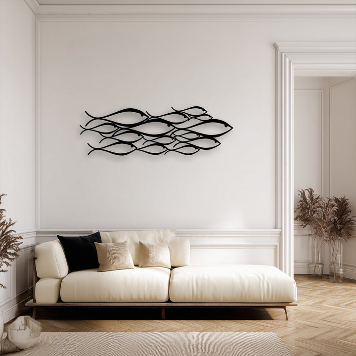 The sleek matte texture of the metal fish decoration wall art stands out against the smooth wall, soft sofa, and woven rug.