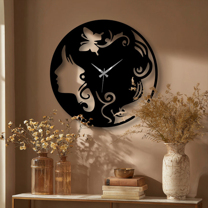 The layered design of the elegant metal artwork wall clock, featuring a woman's silhouette and butterfly, creates striking depth against the beige wall.