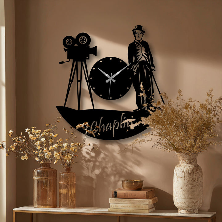 Silhouette of a geometric metal artwork clock showcases circular shapes in the clock face and camera lenses alongside the distinct angular lines of Charlie Chaplin's form.