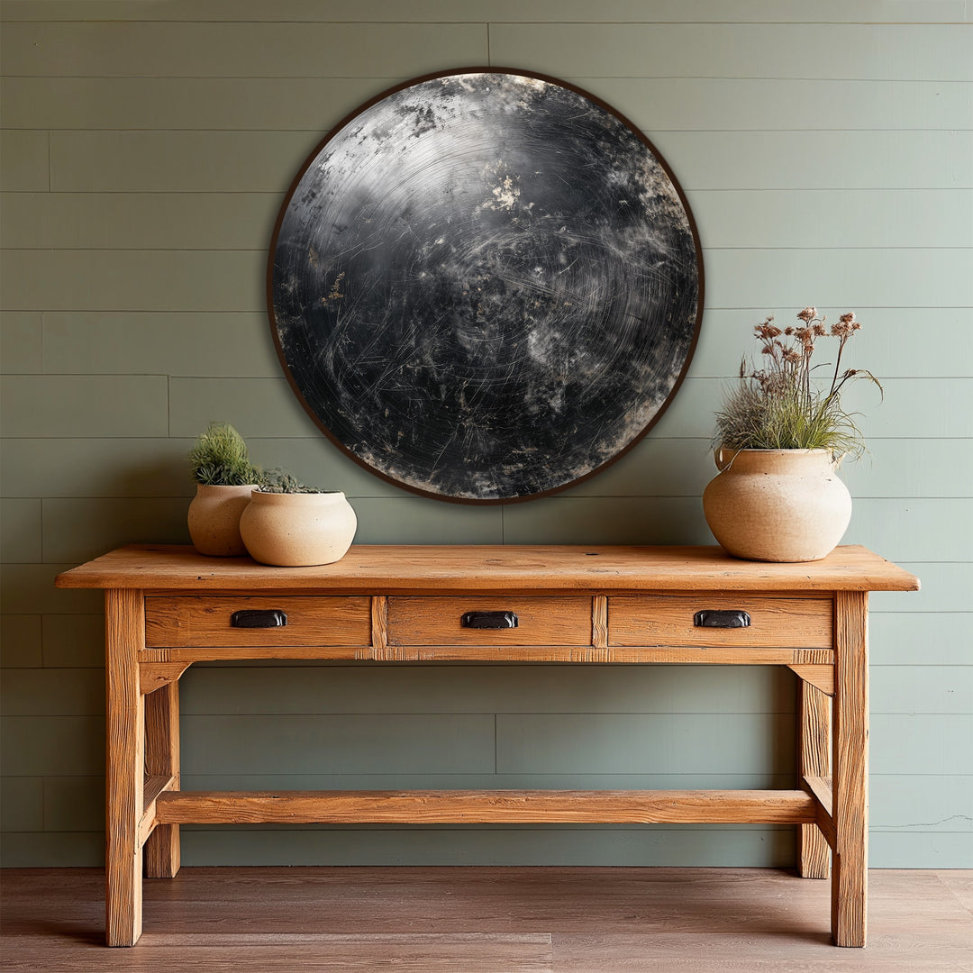 The darkest area of the midnight orbit abstract round wooden oil painting decoration exhibits a scratched texture, contrasting against the table below.