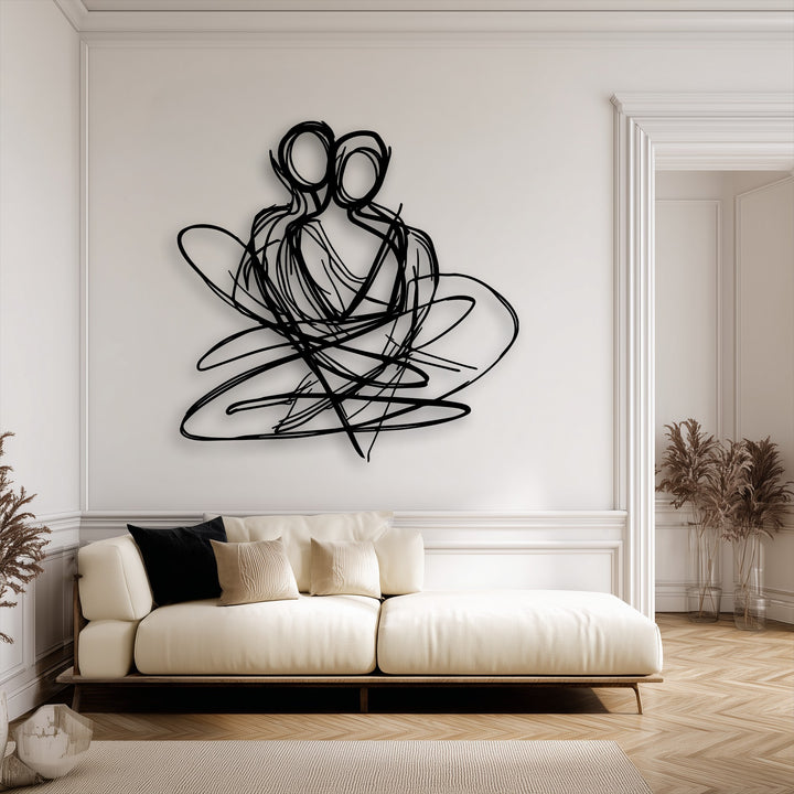 The loudest element is the striking black abstract couple unique metal wall art, depicting embracing figures on a pristine white wall above a sofa.