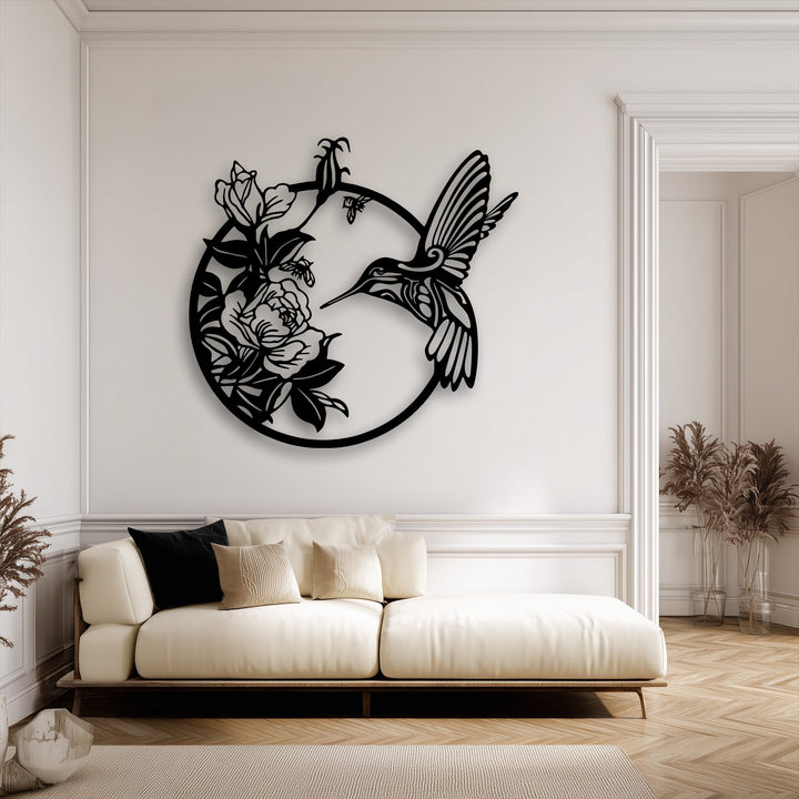 Subtle shadows from the elegant hummingbird and blooming flowers decorative metal art gently contour the cream wall, highlighting its intricate design.