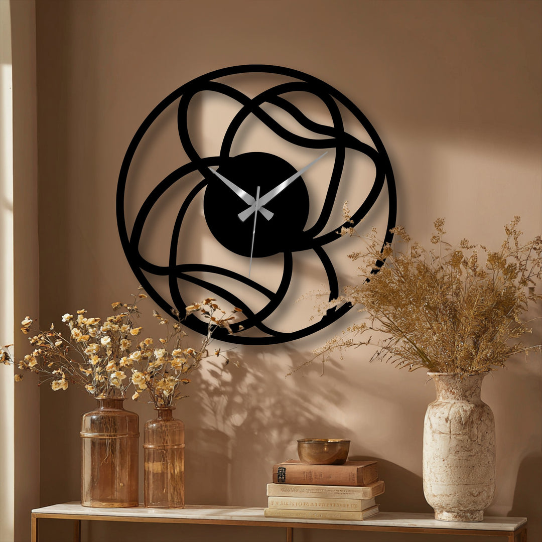 Illuminated by a nearby window, the brightest area of the modern interwoven abstract metal wall clock offers a glimpse of unique metal wall art within the geometric design.