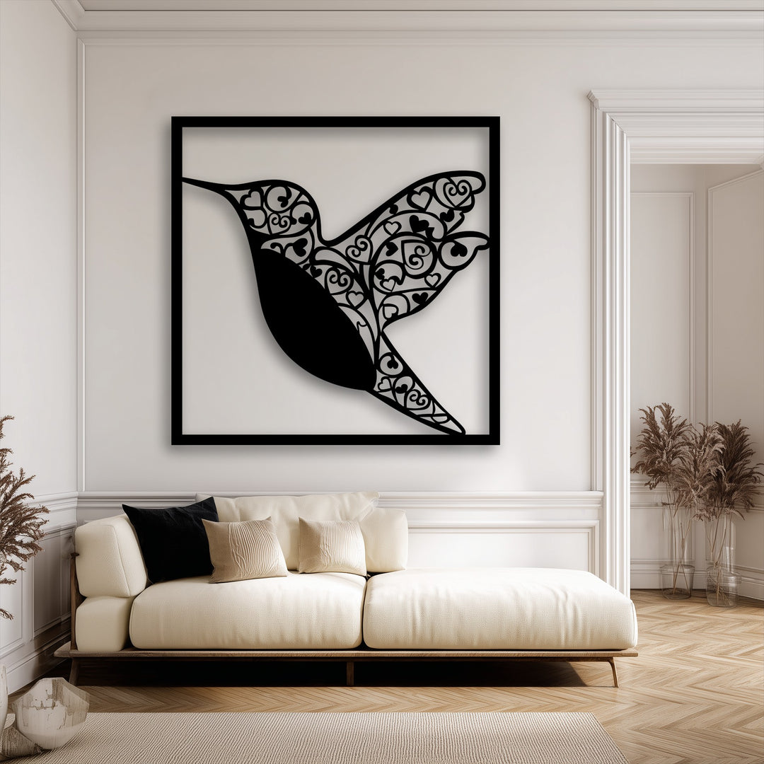 Bright white walls showcase an elegant black hummingbird heart design metal art for wall over a cream sofa.