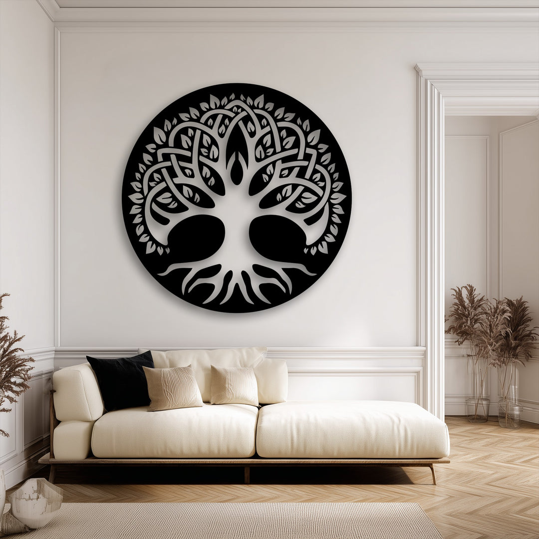 The subtle color saturation highlights the striking black unique metal wall art of the Sacred Tree of Life over a neutral sofa.