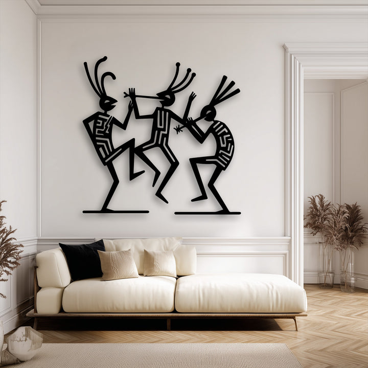 The pristine white wall serves as a brilliant backdrop for striking black tribal dance figures, an exquisite metal art for wall piece.