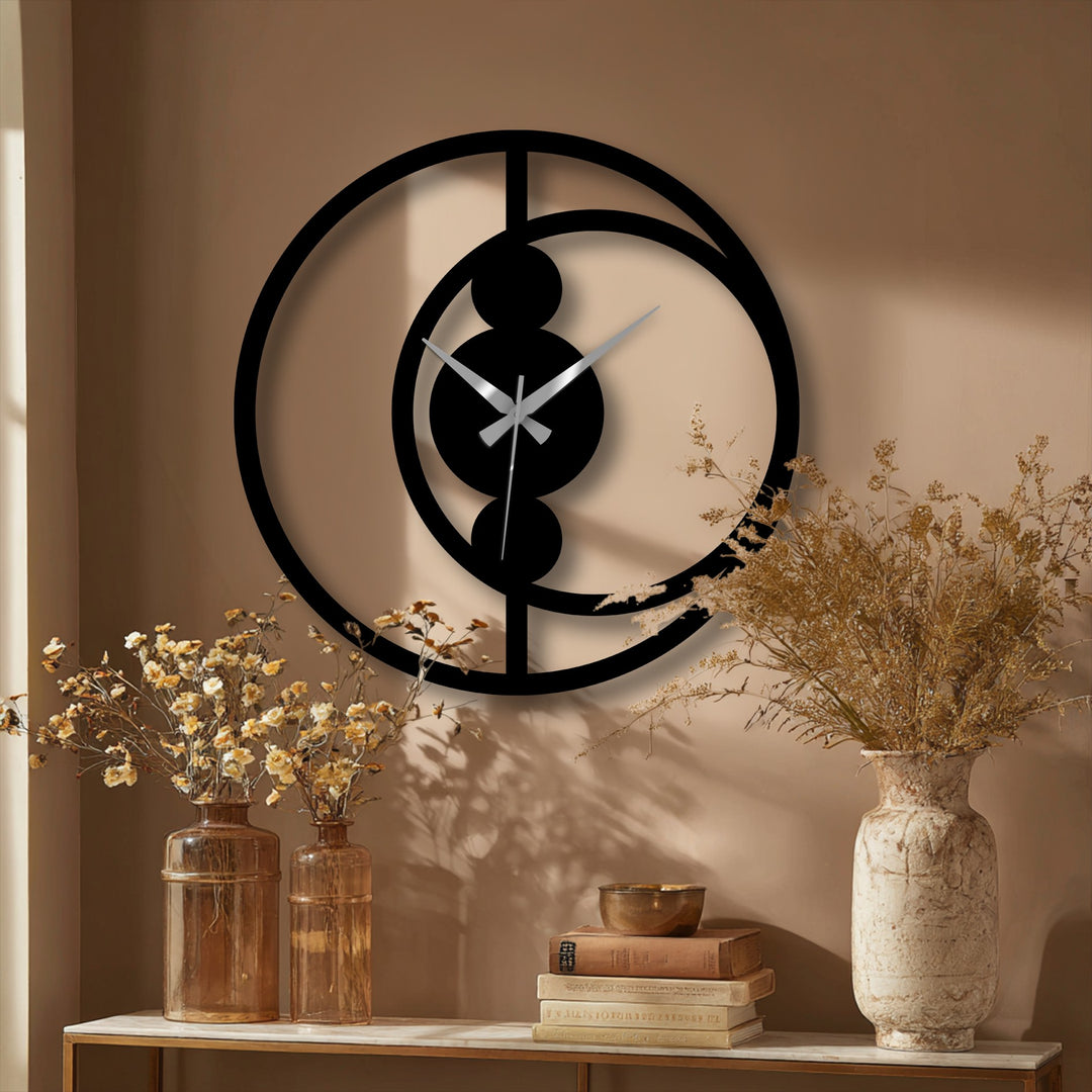 Sharp color contrast highlights the black abstract circular decorative metal art wall clock against the neutral-toned wall, creating a striking modern home decor statement.