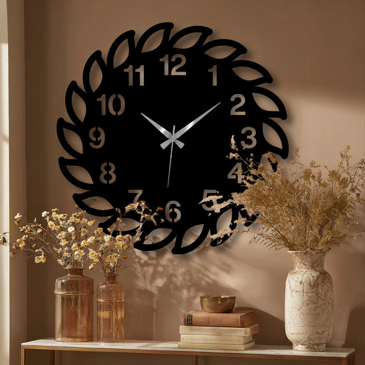 Evoking metal art for wall, the decorative leaf frame wall clock features organic forms reminiscent of a natural wreath design with minimalist clock hands.