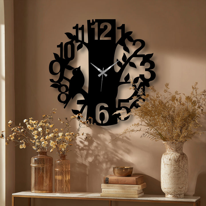 Negative space highlights the tree and bird silhouette in this nature-inspired metal wall decor, with a whimsical glass art clock face and contemporary design.