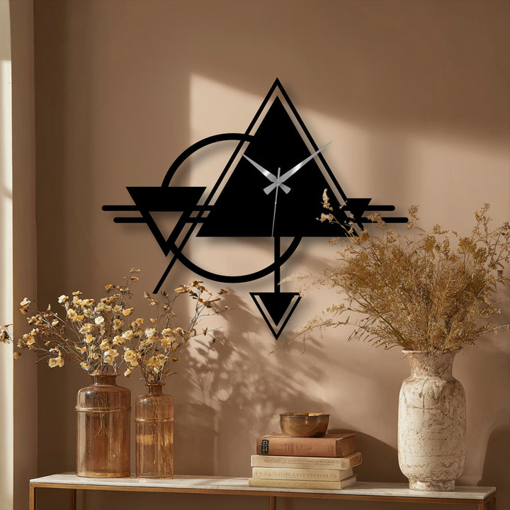 Illuminating the tan wall, the silver clock hands accent the bold geometric black frame of this decoration wall art clock featuring an abstract triangle and circle design.