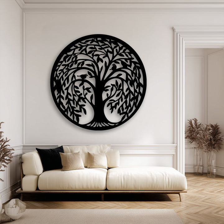 The striking focal point is a large, round, black Tree of Life metal artwork with intricate branches and birds, elegantly decorating a light wall.