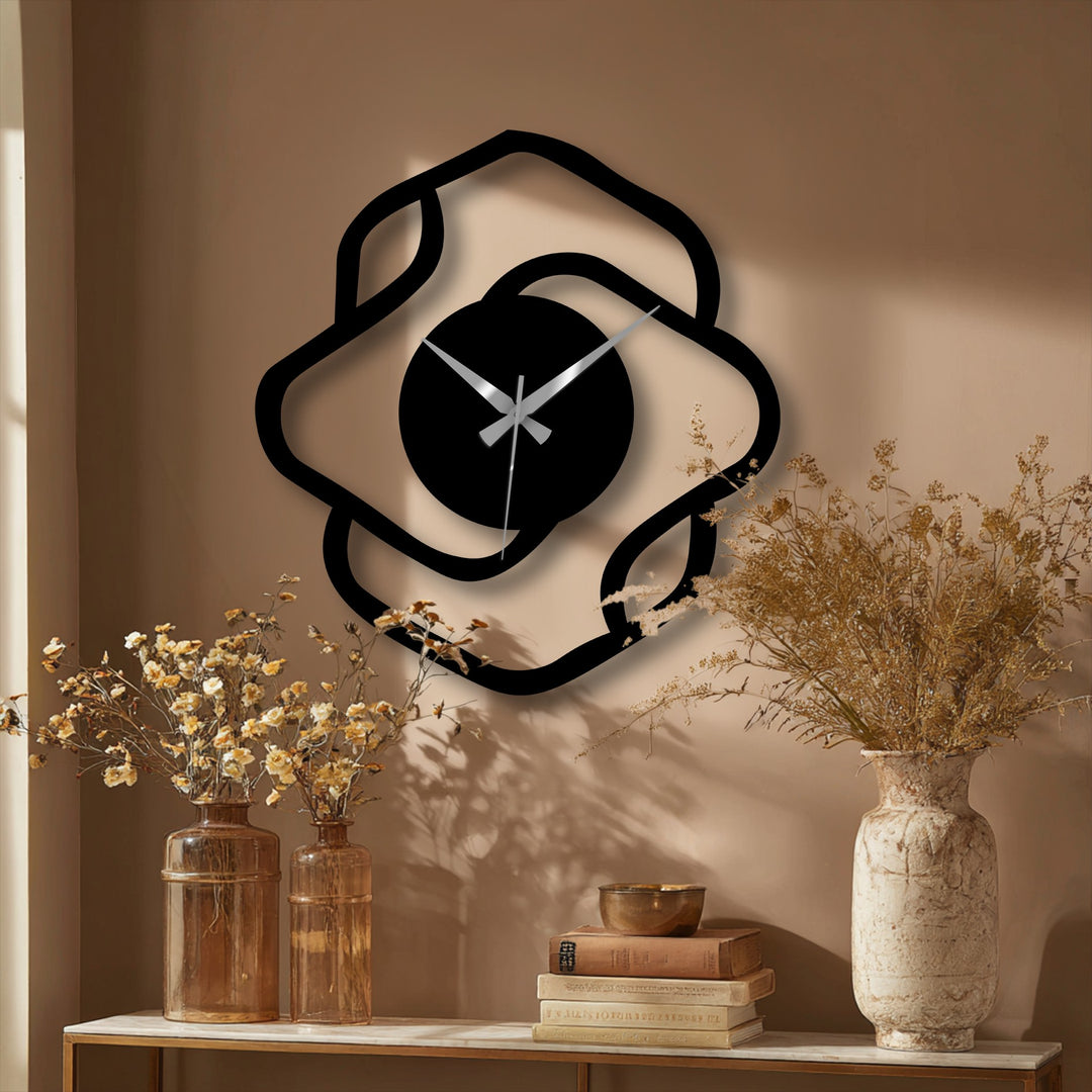 Smooth surface texture defines the abstract organic shape of this modern decorative metal art wall clock, contrasting with the wall's subtle roughness.