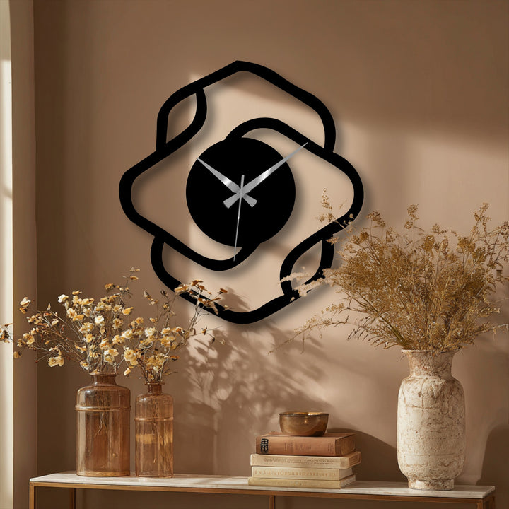 Smooth surface texture defines the abstract organic shape of this modern decorative metal art wall clock, contrasting with the wall's subtle roughness.