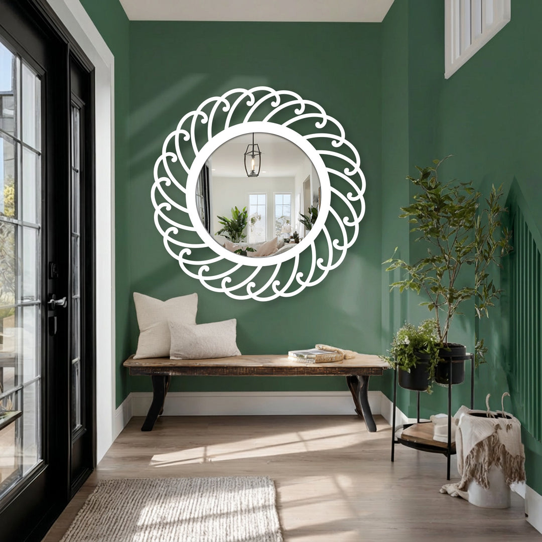 Transitional hues on the green wall highlight a swirl pattern round metal wall mirror, an example of artistic decoration wall art reflecting a brightly lit interior.