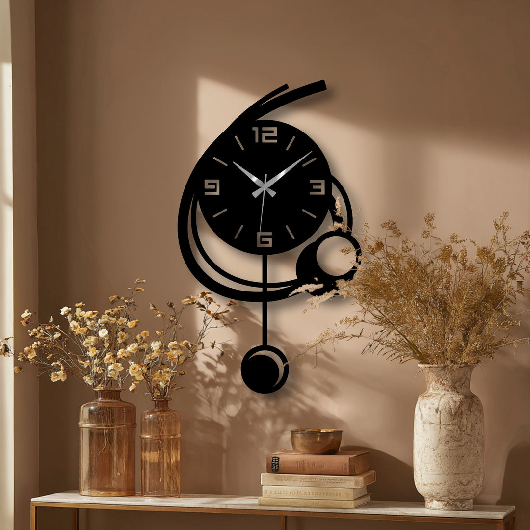 Neutral tan background showcases the modern orbit pendant metal wall decor clock, creating a minimalist geometric display with its curved design.