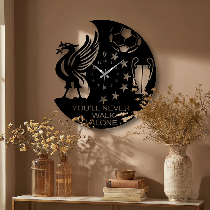 Matte black finish highlights the unique metal wall art of the Victory Spirit metal wall clock, featuring a football, trophy, and Liverpool FC details.