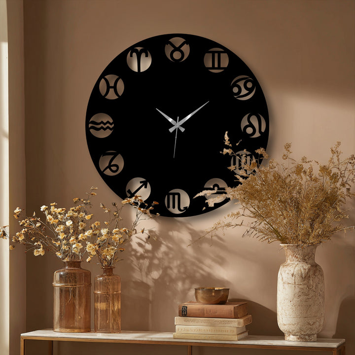 The background features a warm, neutral-toned wall and an elegant shelf with dried flowers and books, enhancing the modern astrology decorative metal art.
