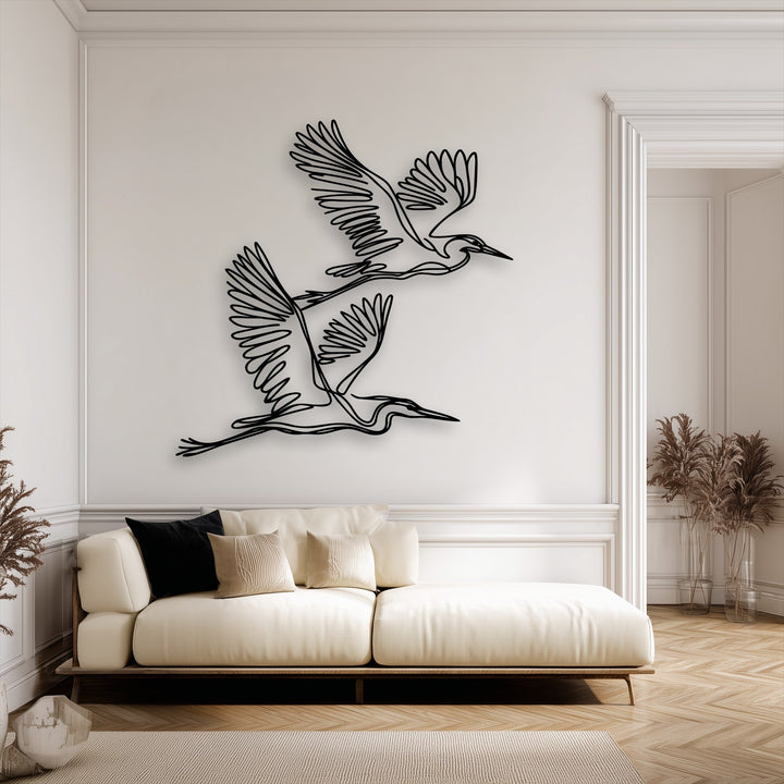 The diagonally oriented minimalist metal decoration wall art features two graceful flying herons crafted from elegant continuous lines.