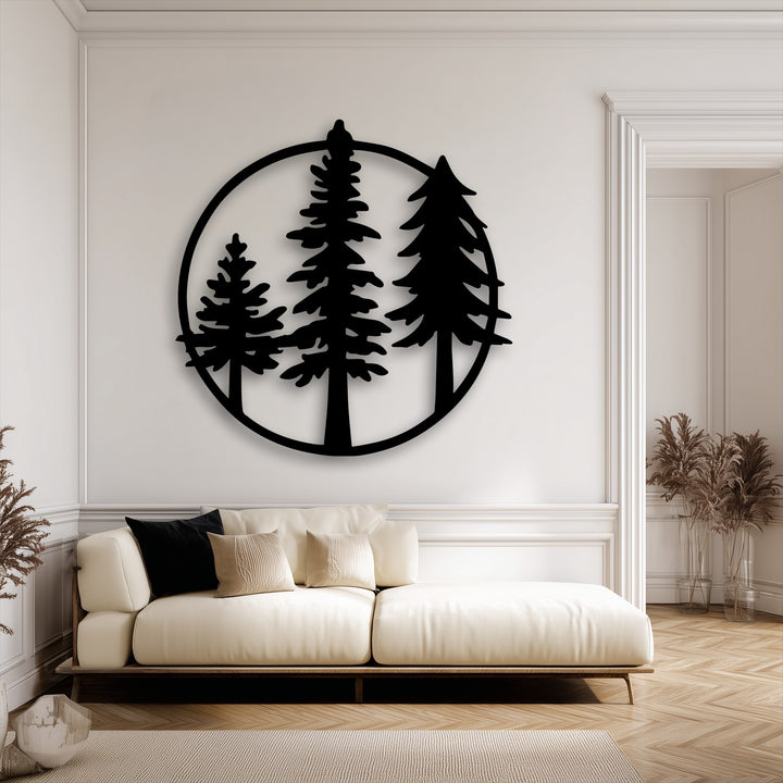The clean black border of the circular minimalist forest metal artwork, featuring three evergreen trees, stands out against a white wall.