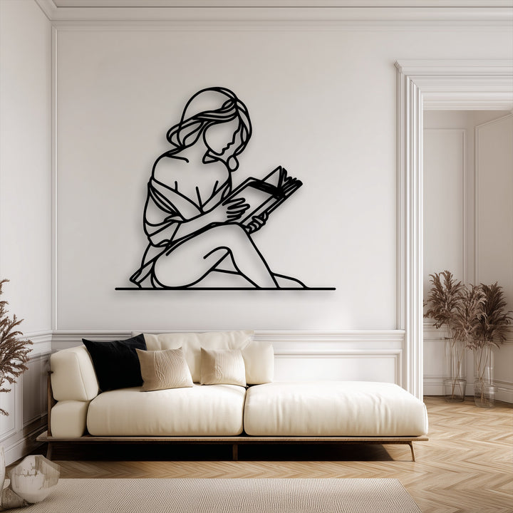 A warm, inviting color temperature permeates this cozy room featuring a minimalist decorative metal art of a reading woman.