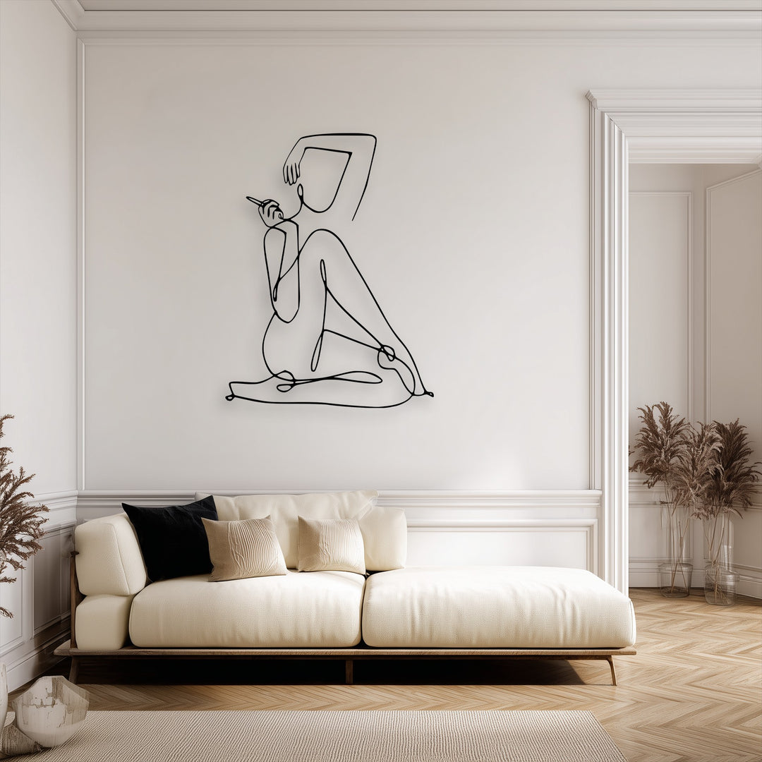 The elegant focal point is a striking minimalist female line art metal wall decoration, featuring a seated abstract figure on a pristine white wall.