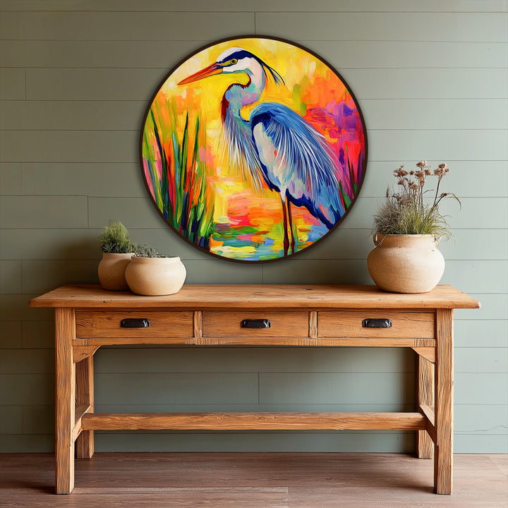 Evoking the organic forms found in nature, this round oil painting home decor showcases a colorful heron amidst vividly painted reeds and a serene sunset marsh.