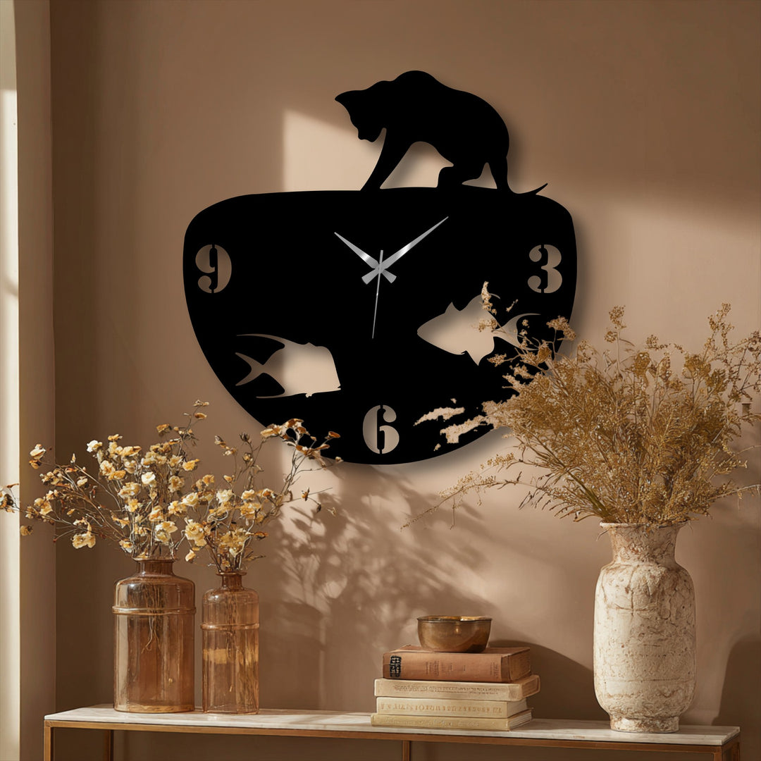 A prominent black metal wall decor clock displays a captivating layering effect, with a curious cat silhouette atop gazing at the fish bowl design.