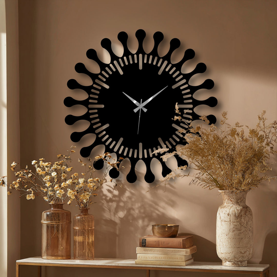 As the modern sunburst, I offer a unique timekeeping experience through decorative metal art, displayed prominently on a neutral wall above vases and books.