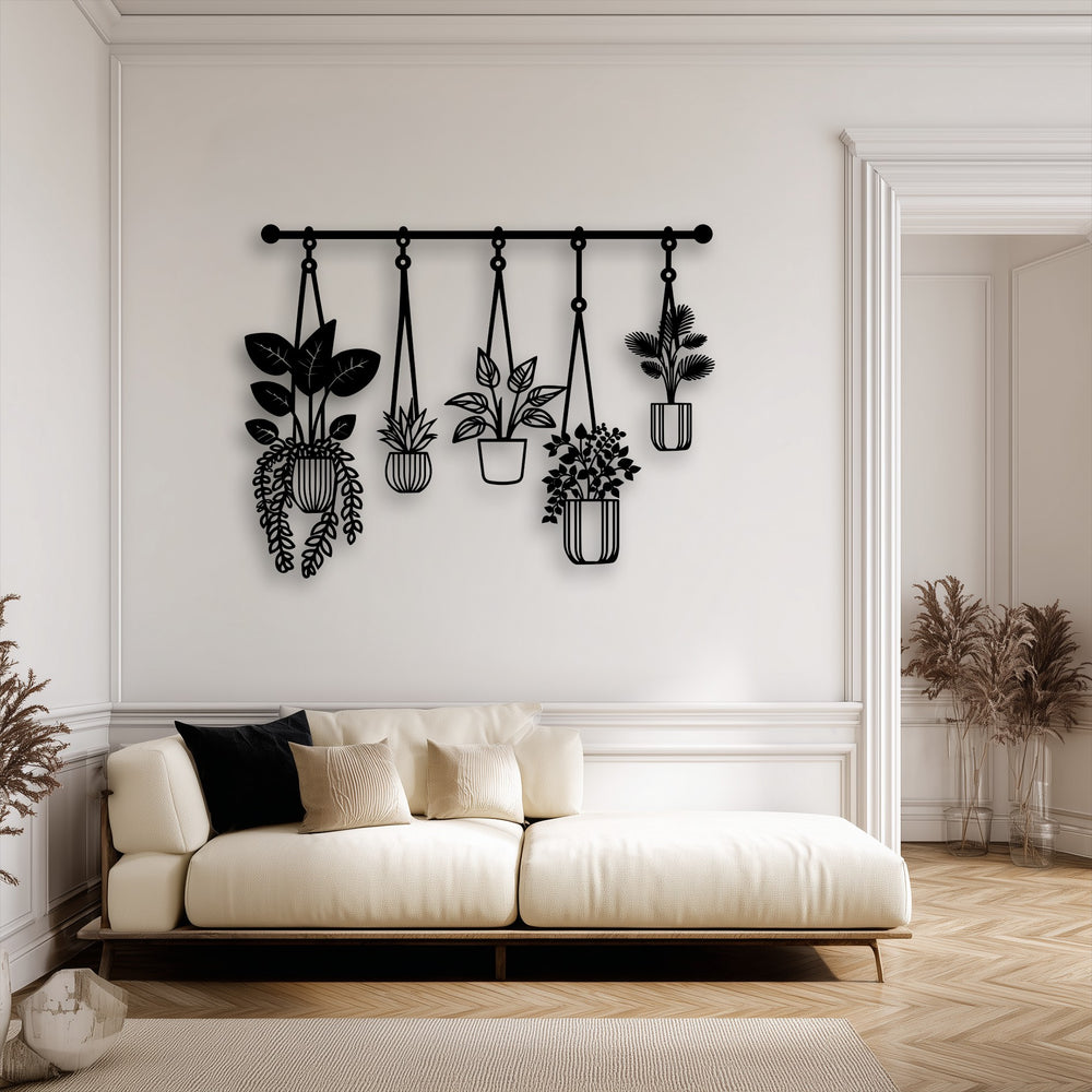 Dramatic shadows are cast by the sleek black hanging plants metal art for wall, highlighting its modern botanical decor against the light wall.