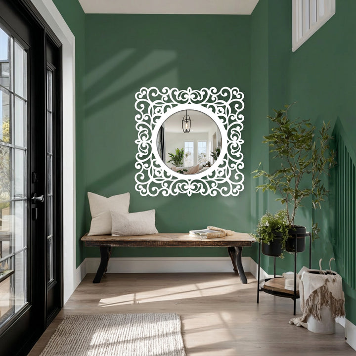Deep green walls dramatically contrast with the bright white of an ornate framed wall mirror, highlighting the mirror's elegant baroque scroll details.