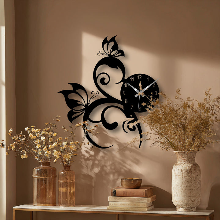 The bold, intricate black butterfly and vine clock is the loudest element, a piece of unique metal wall art with an elegant nature design.