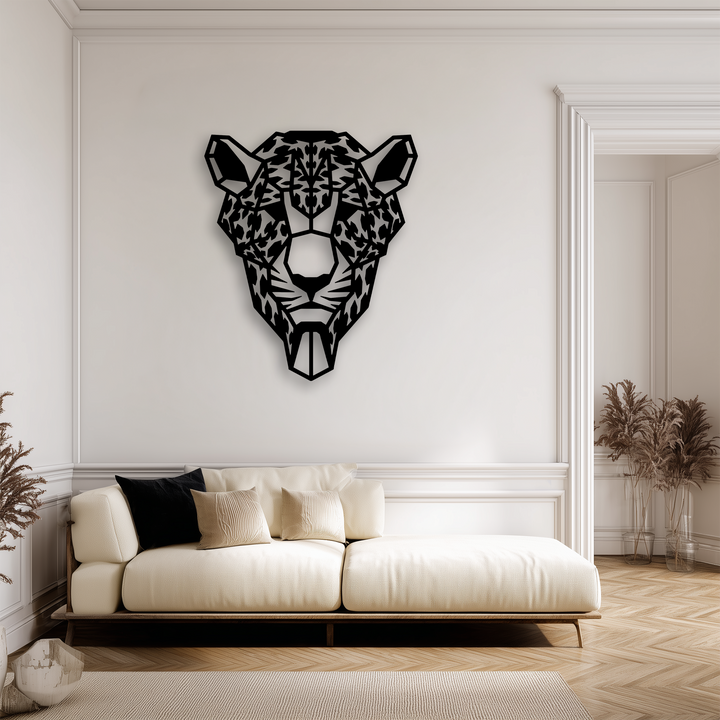 With notably low color saturation, a striking black geometric tiger head metal wall decor adorns a crisp white wall above a cream sofa.
