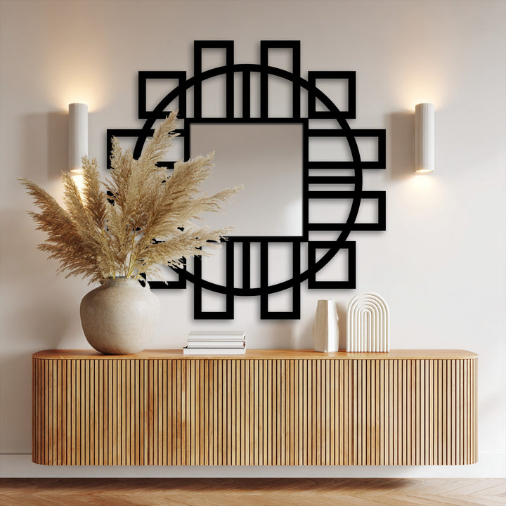 Foreground shows a fluted wooden console supporting a neutral vase filled with pampas grass, set beneath a striking geometric stained glass wall mirror.