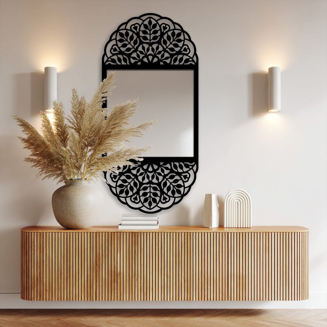 With a subtle color saturation, the floral mandala pattern mirror's black ornamental frame enhances a modern mirror, reflecting light beside minimalist wall sconces.