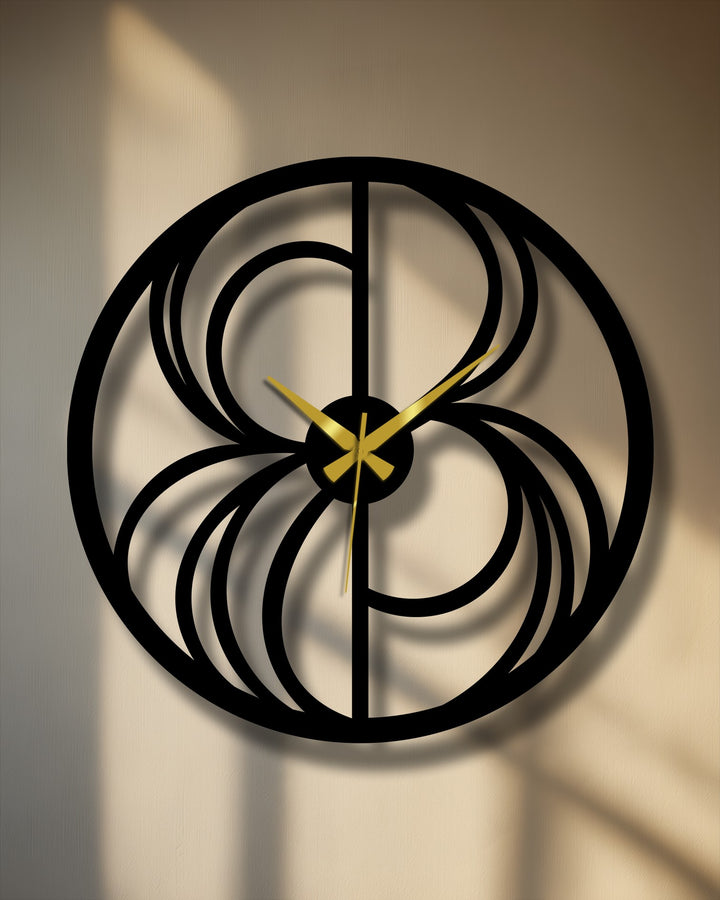 Illuminated by sunlight, the brightest area highlights the decorative metal art of the abstract swirl clock, a modern geometric piece with golden hands.