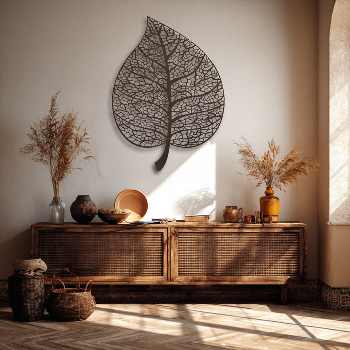 The matte bronze finish of the intricate botanical leaf silhouette metal decoration wall art complements the rustic interior.