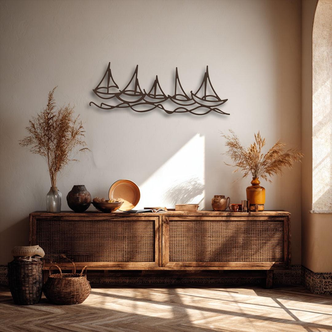 A striking minimalist metal wall decor piece with five dark brown sailboats on undulating waves, prominently displayed above a rustic console table.