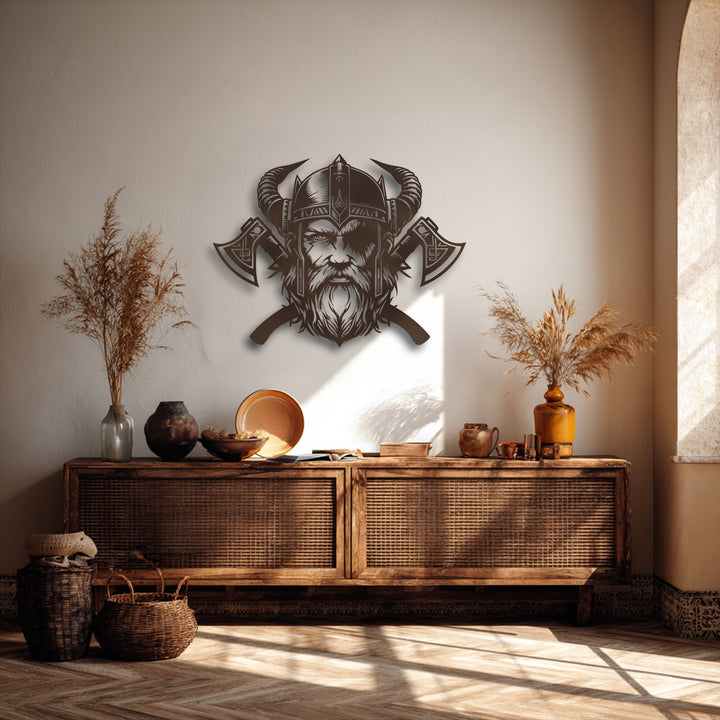 The metal wall decor of a fierce Viking warrior with a horned helmet and axes creates prominent layers and depth against the textured wall, enhanced by dramatic shadows.