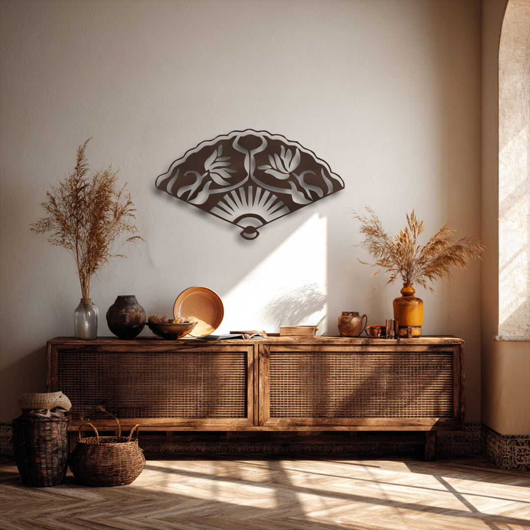 Warm sunlight creates a smooth transition of colors across the wall behind the dark Oriental fan metal wall decor.