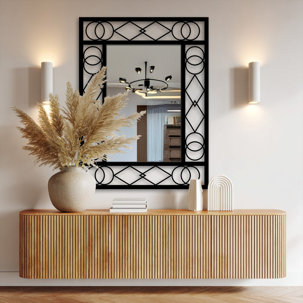 Highlighting the organic forms of the decorative vase filled with feathery pampas grass, and the patterned black metal frame around the modern wall mirrors.
