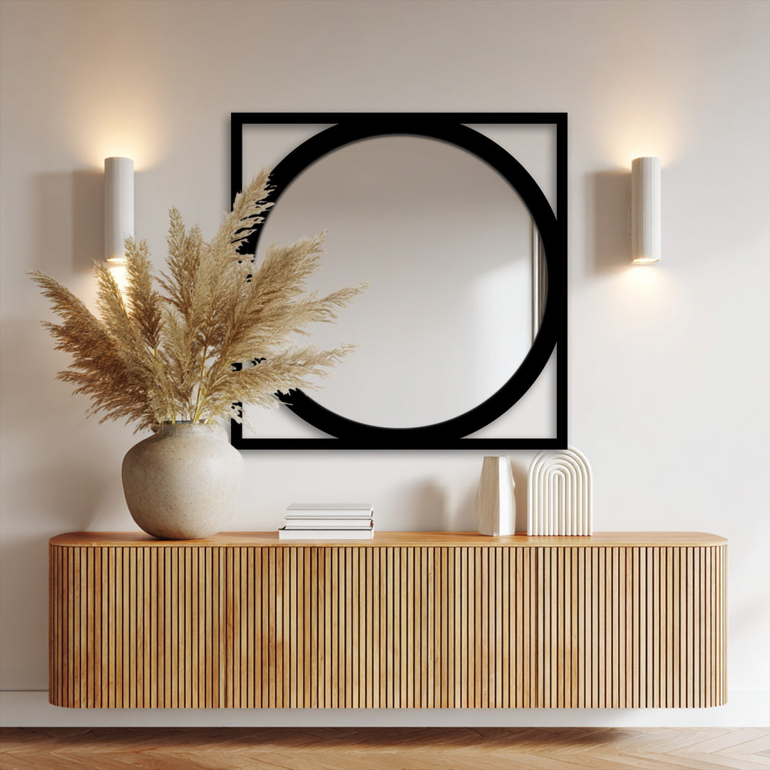 The darkest area, a bold black geometric decorative metal art frame, holds a round mirror above a slatted console.
