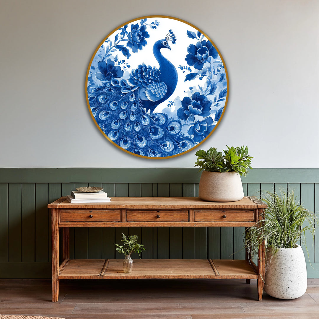 Arranged on a wooden console table, a large potted plant complements the round indigo peacock among blossoms oil painting wall art hanging above.