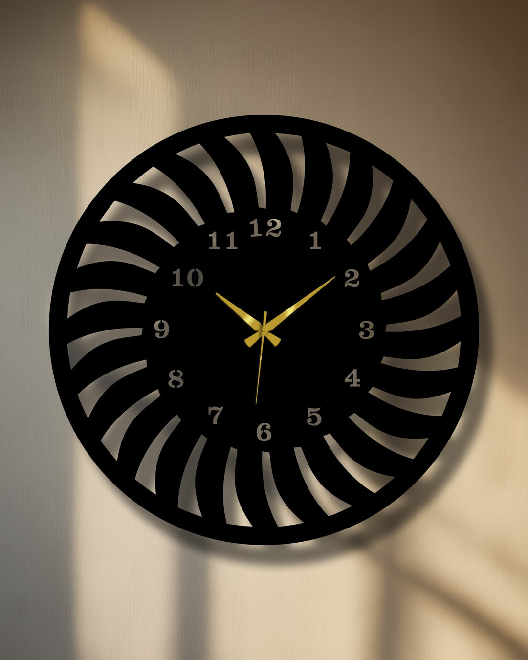 The intricate negative space of this radial pattern metal wall decor creates a modern spiral design with gold hands on a sunlit wall.