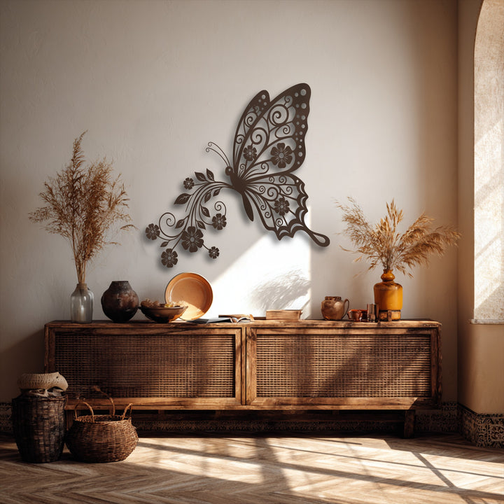 Two woven baskets rest on a sunlit herringbone wooden floor with strong diagonal shadows, providing a natural base for the elegant butterfly metal artwork.