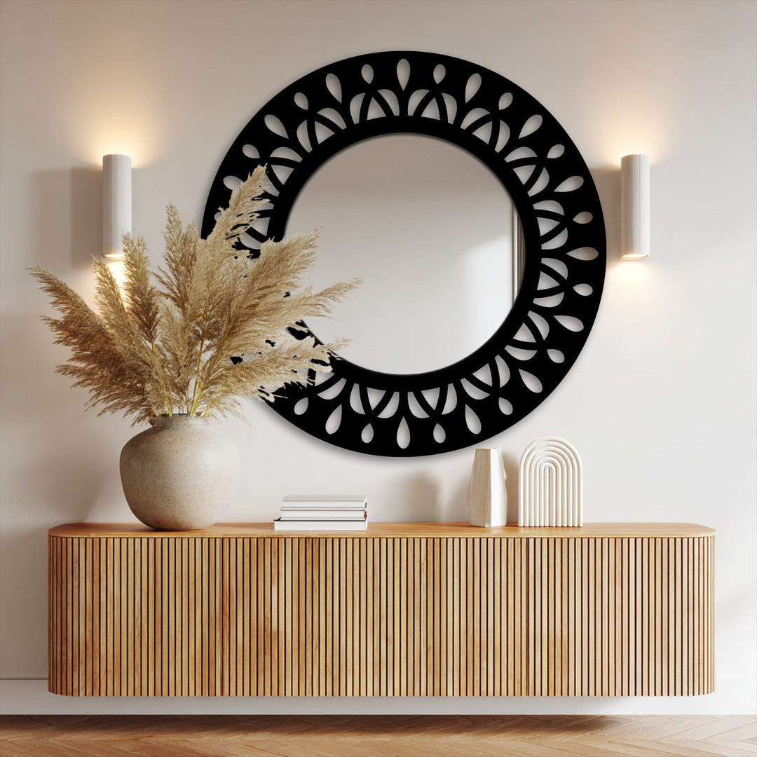 The realistic detail showcases the intricate black metal leaf motif of this decorative mirror, beautifully reflecting the room's subtle textures.