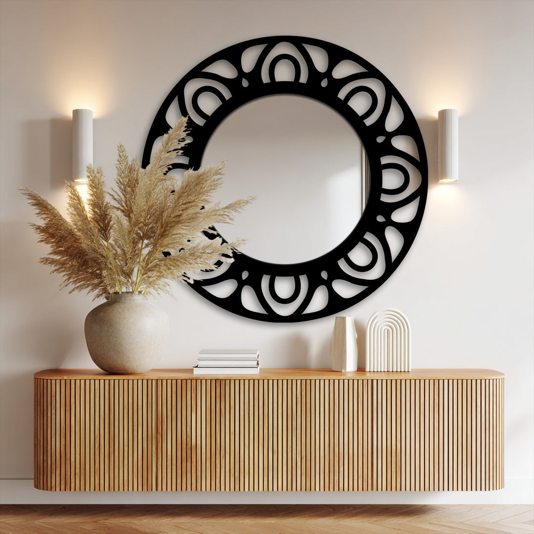 Moderately saturated tones highlight the modern mirror's pattern ring frame above a blonde wood cabinet with decorative vases.