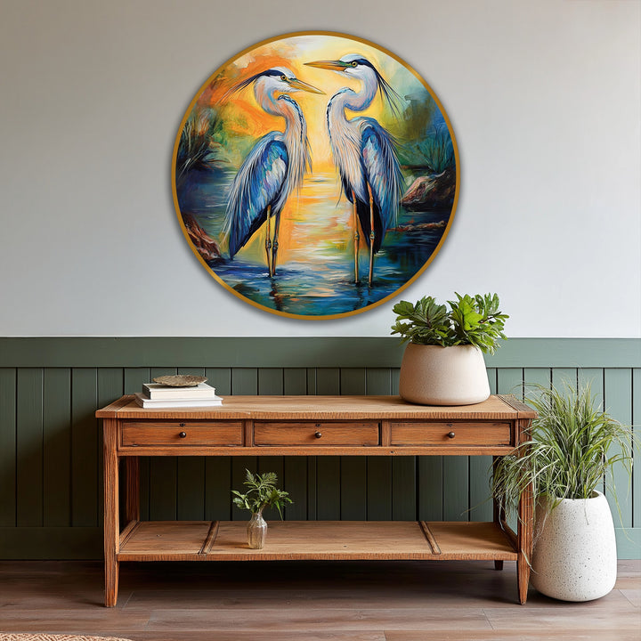 Graceful herons in the 'Sunset Reflections' oil painting art piece stand tall, capturing the sunset's reflection in this stunning circular wildlife scene.