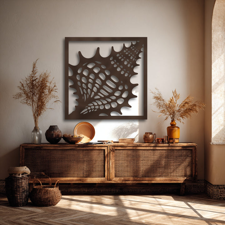 A light beige textured wall forms the elegant background for a unique seashell frame metal decoration wall art, with sunlight accentuating textures.