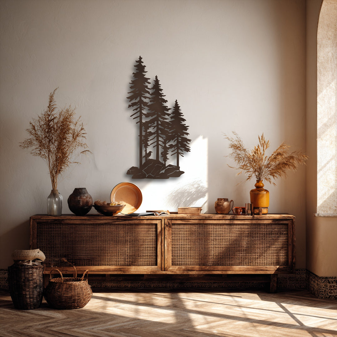 The matte brown finish of the decorative metal art depicts a forest silhouette with pine trees, rocks, and a small bird.